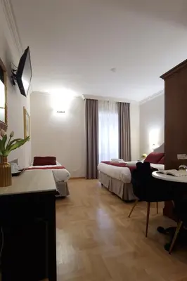 a hotel room with two beds and a desk at Affittacamere Boncompagni Suite in Rome