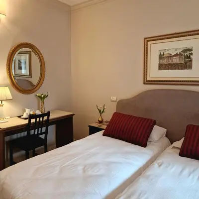 a room with two beds and a desk and a mirror at Affittacamere Boncompagni Suite in Rome