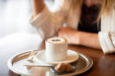 a cup of coffee sitting on a table with a person at Affittacamere Boncompagni Suite in Rome