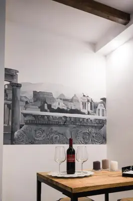 a bottle of wine sitting on a table with two glasses at Leonina 75 Holidays in Rome