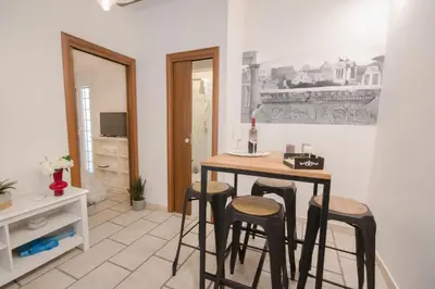 a kitchen with a table and stools with a bottle of wine at Leonina 75 Holidays in Rome