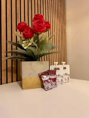 a vase of red roses sitting on a table with some cookies at Leonina 75 Holidays in Rome