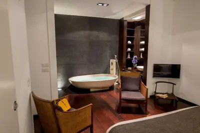 a bathroom with a tub and a table and a chair at SK ROME Apartment Luxury Torre Argentina in Rome