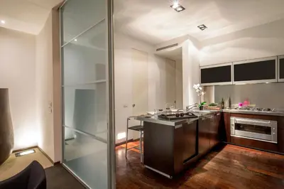 a kitchen with a counter and a glass wall at SK ROME Apartment Luxury Torre Argentina in Rome