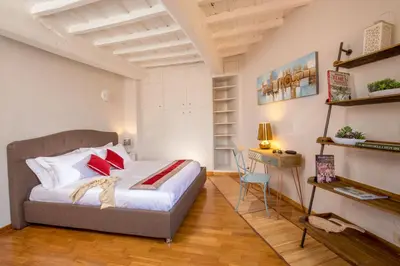 a bedroom with a bed with red pillows and a desk at SK ROME - Apartment Luxury Navona in Rome