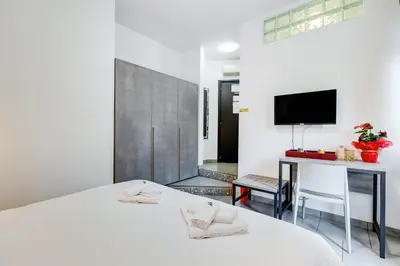 a bedroom with a bed and a desk and a tv at B&B Casa Der Poeta in Rome