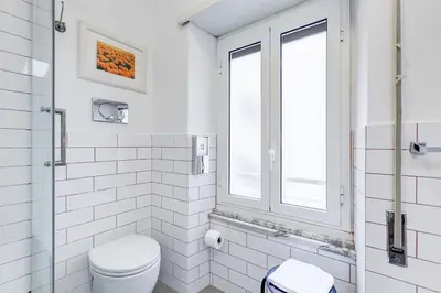 a white bathroom with a toilet and a window at B&B Casa Der Poeta in Rome
