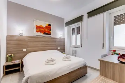 a bedroom with a large white bed and a window at B&B Casa Der Poeta in Rome