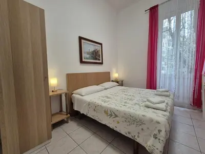 a bedroom with a bed and a window with red curtains at A casa di Alex Vatican in Rome