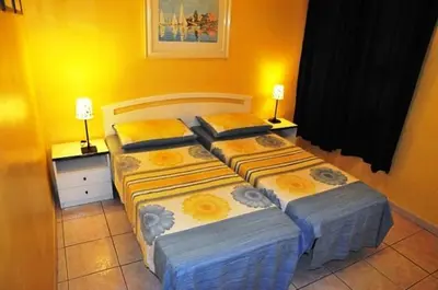 two beds in a bedroom with two lamps on tables at A casa di Alex Vatican in Rome