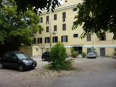 two cars parked in a parking lot in front of a building at Casa ParticulART in Rome