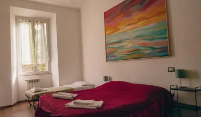 a bedroom with a red bed and a painting on the wall at Casa ParticulART in Rome