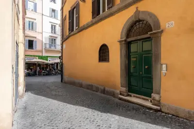 an alley with a green door on a building at Antica dimora navona in Rome