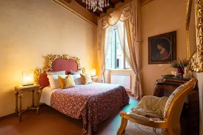 a bedroom with a bed and a chair and a window at Antica dimora navona in Rome