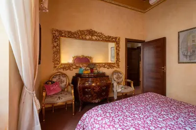 a bedroom with a bed and a mirror and chairs at Antica dimora navona in Rome