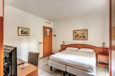a bedroom with a bed and a desk and a tv at Guest House Masterintrastevere in Rome
