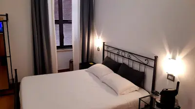 a bedroom with a white bed with two lamps at Guest House Masterintrastevere in Rome