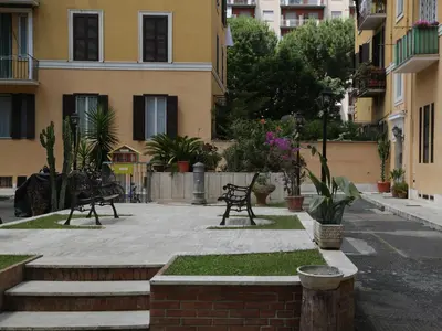a courtyard with benches and plants and buildings at Guest House Masterintrastevere in Rome