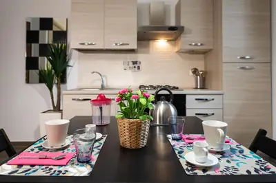 a kitchen with a table with a tea kettle and flowers at Domus Caracalla Nel Cuore Di Roma in Rome