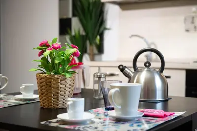 a kitchen counter with a table with a tea pot and flowers at Domus Caracalla Nel Cuore Di Roma in Rome