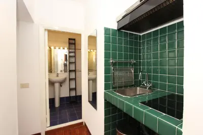 a green tiled bathroom with a sink and a mirror at Penna Flats in Rome
