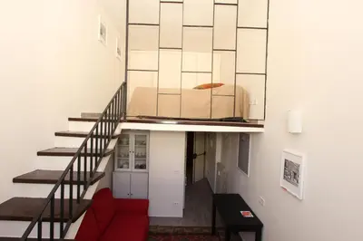 a living room with a red couch and a staircase at Penna Flats in Rome