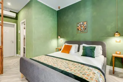 a bedroom with a bed with green walls at Ripetta Natural Suites in Rome
