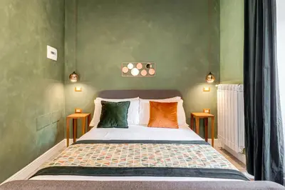 a bedroom with a bed with colorful pillows at Ripetta Natural Suites in Rome