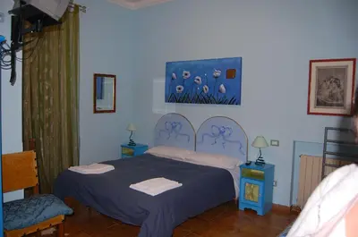 a bedroom with a bed with a blue bedspread at Casa Cleo in Rome
