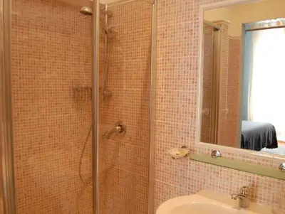 a bathroom with a shower with a sink and a mirror at Casa Cleo in Rome
