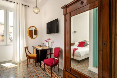 a hotel room with a bed and a table and chairs at Guesthouse Serafino in Rome