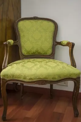 a green chair sitting in a room at Guesthouse Serafino in Rome