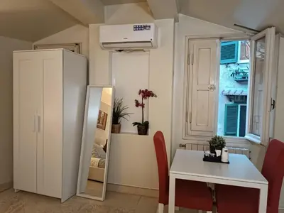 a small room with a table and a white refrigerator at Navona Private Rooms bnb in Rome