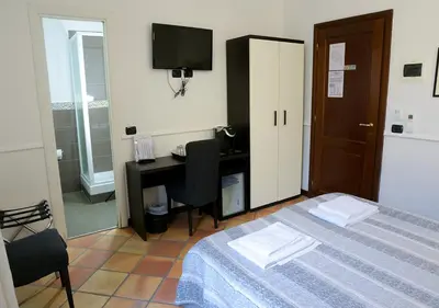 a bedroom with a bed and a desk with a computer at GH Colosseum in Rome