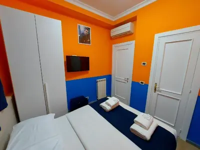 a small room with a bed and a tv at Hotel Positano in Rome
