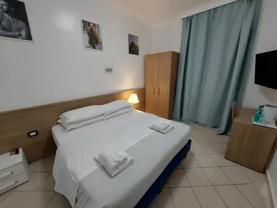 a bedroom with a white bed with towels on it at Hotel Positano in Rome