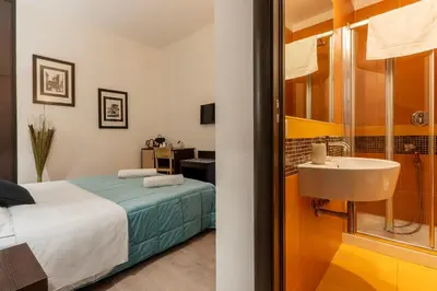 a bathroom with a bed and a sink in a room at Flowerome in Rome