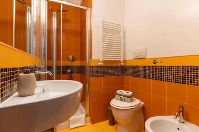 a yellow bathroom with a sink and a toilet at Flowerome in Rome