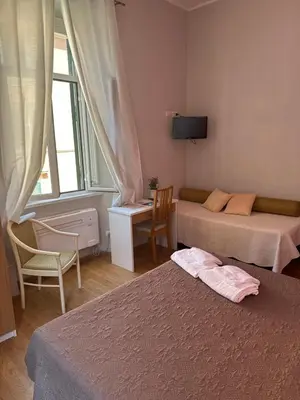 a hotel room with two beds and a television at Trani B&T Rooms in Rome