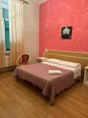 a bedroom with a bed and a red wall at Trani B&T Rooms in Rome