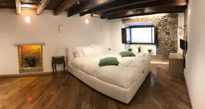 a large white bed in a room with a brick wall at La Casa Dei Marmi in Rome