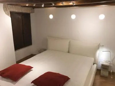 a bedroom with a white bed with two red pillows at La Casa Dei Marmi in Rome