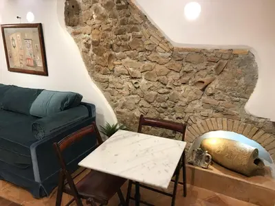 a living room with a couch and a stone fireplace at La Casa Dei Marmi in Rome