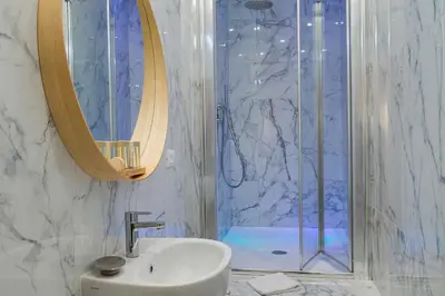 a bathroom with a sink and a shower with a mirror at Giolitti Suite in Rome