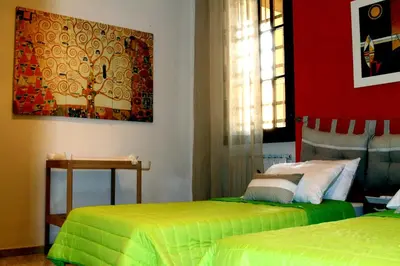 a bedroom with two beds and a painting on the wall at MANDRUCHELLO'S in Rome