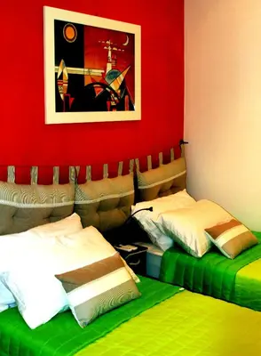 a bedroom with two beds and a red wall at MANDRUCHELLO'S in Rome