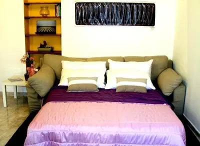a bed in a room with a couch and pillows at MANDRUCHELLO'S in Rome