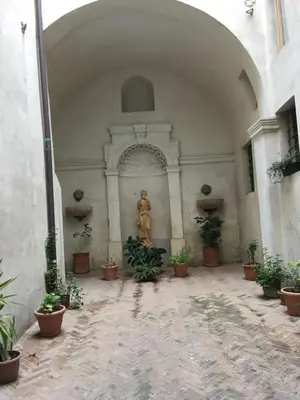 a building with a statue in a courtyard with plants at Domus next Campo de'Fiori with thermal shower in Rome