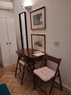 a room with a wooden table and two chairs at Domus next Campo de'Fiori with thermal shower in Rome