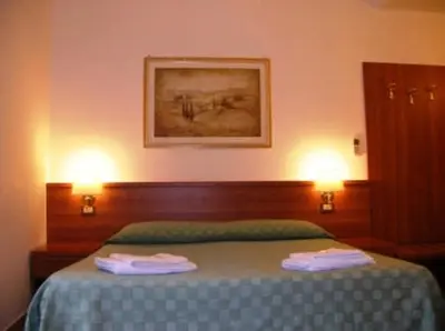 a bedroom with a bed with two lights on it at Emanuela Guest House in Rome